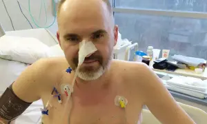 Mężczyzna w szpitalu z sondą nosową i elektrodami na klatce piersiowej. Jego walka z rakiem trzustki i rokowania są trudne, ale nie traci nadziei.
