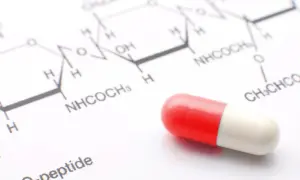 Kapsułka na tle wzoru chemicznego. Może to być element testu na narkotyki lub badania leków.